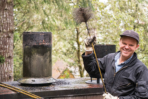 Chimney Sweep cleaning  on roof of house cleaning dirty chimneyChimney Sweep cleaning  on roof of house cleaning dirty chimney